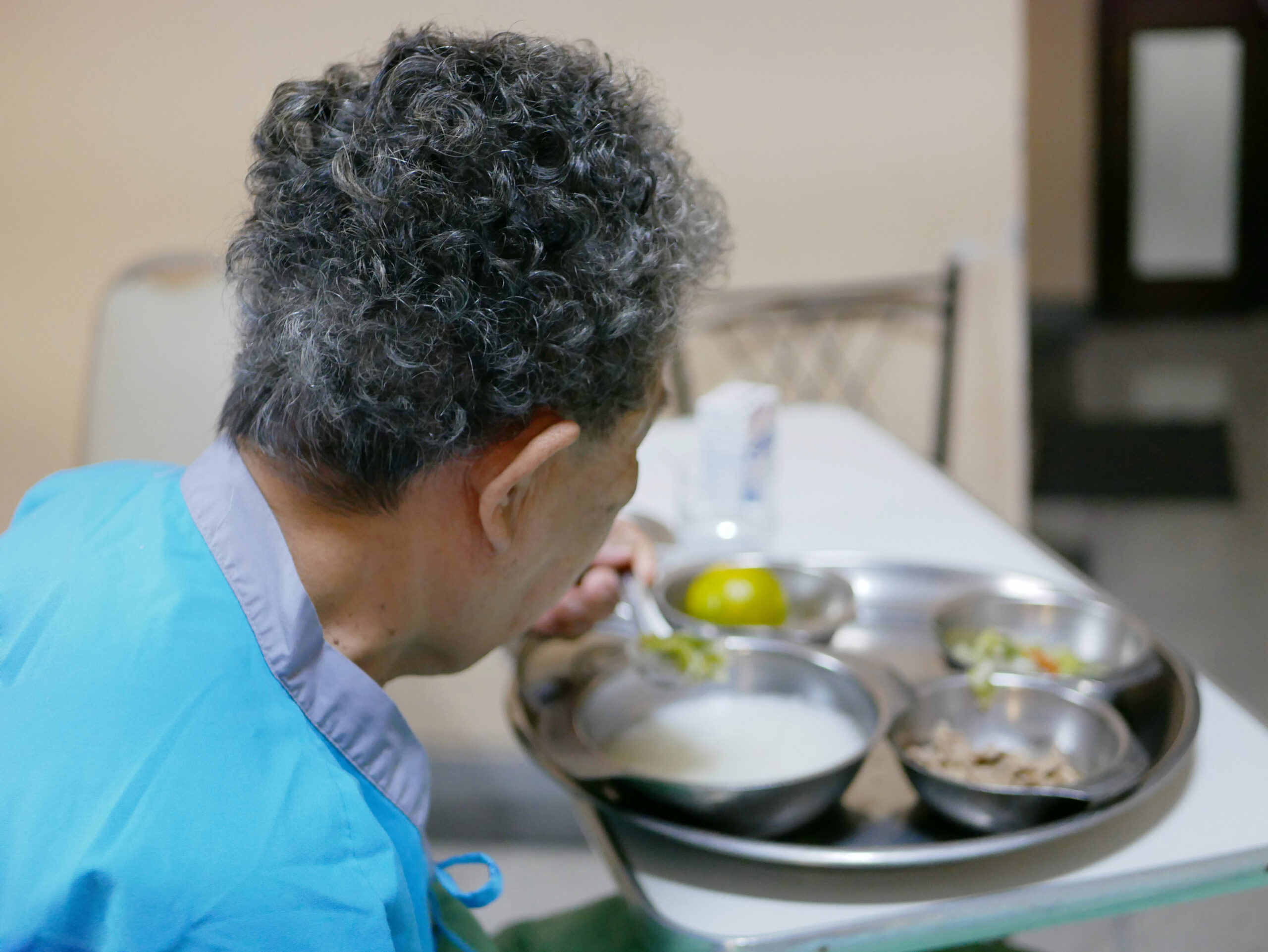 elderly sick woman eating patient food provided by a hospital